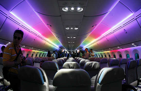 Economy-class cabin of the Boeing 787 Dreamliner is lit with rainbow coloured LED lighting during an media tour of the aircraft ahead of the Singapore Airshow.