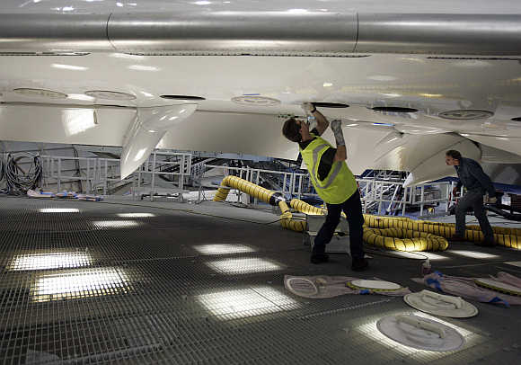 Boeing aircraft maintenance technician Bill Lucyk works on the underside of the first 787 Dreamliner as it's readied for it's first test flight at the Boeing company's Everett plant.