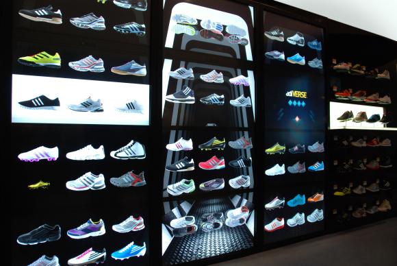 Images of shoes displayed on a virtual wall at an Adidas store.