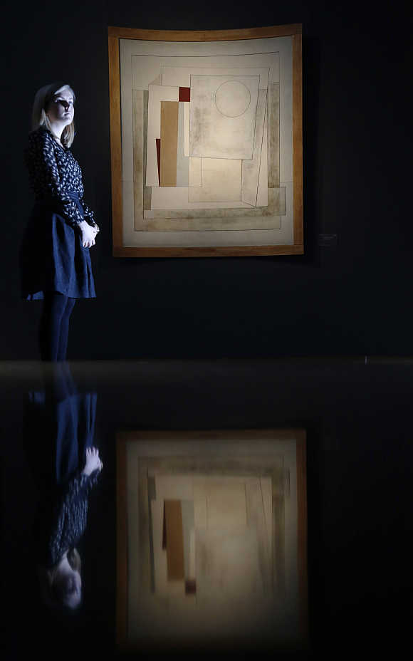A employeee poses with Ben Nicholson's 'October 1949 (composition-Rangitane)' at Christie's auction house in London.