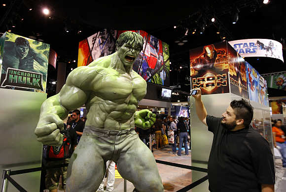 An attendee takes a picture of a life size Incredible Hulk in San Diego, California.