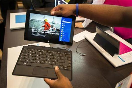 Sales staff demonstrate the Microsoft Surface during the opening of Microsoft's retail store in New York's Times Square.