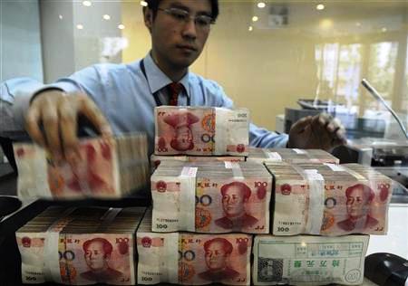 An employee counts Chinese yuan banknotes at a bank in Hefei, Anhui province.