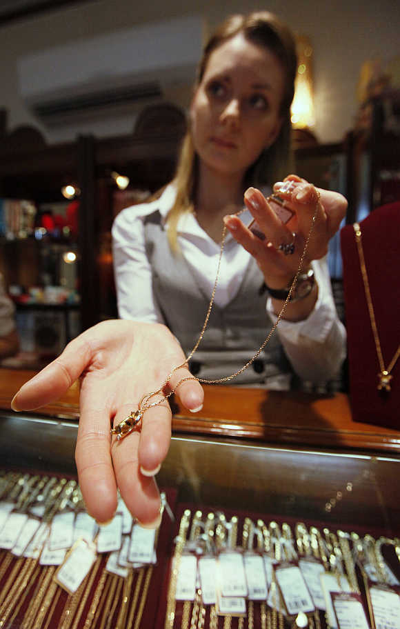 An employee displays gold jewellery in Russia's Siberian city of Krasnoyarsk.