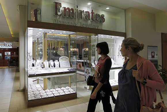 Women walk past the Emirates Diamonds shop at Gold and Diamond Park, a shopping mall specialised in gold and diamond retailing, in Dubai.