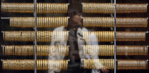 A woman is reflected on the window of a jewellery shop where gold bangles are on display in Istanbul, Turkey.