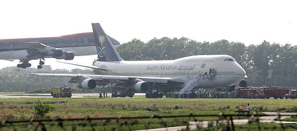 A Bangladeshi aircraft lands near a Saudi Airlines 747 plane at Dhaka's Zia International Airport.