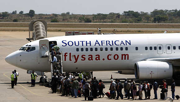 Passengers board a South African Airways Boeing 737 aircraft at the Kamuzu International Airport in Lilongwe, Malawi.