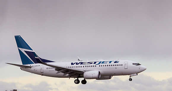 A WestJet airplane comes in for a landing at Calgary International airport, home of Canada's WestJet Airlines in Calgary, Alberta.