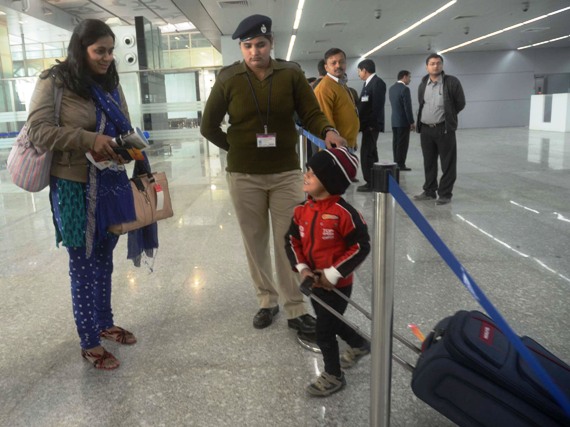A mother and a child engage in a conversation as a security guard looks on at the new Kolkata airport.