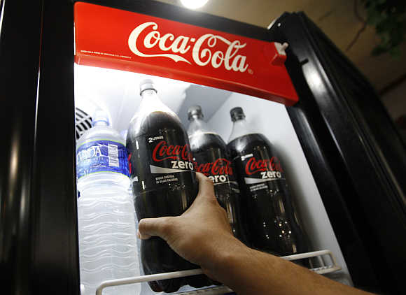 A man takes a bottle of Coke Zero out of a fridge at a supermarket in Caracas, Venezuela.