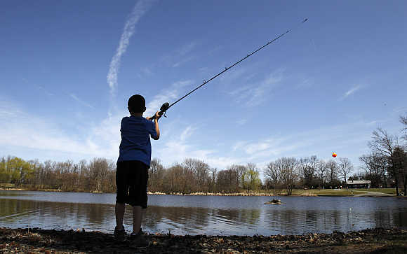 Zach Andrews casts a fishing line into a pond at Bellevue State Park near Wilmington, Delaware.