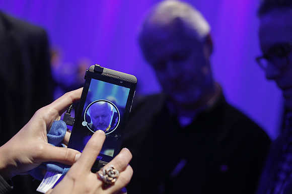 A man uses an Apple iPhone to photograph new BlackBerry devices during the Blackberry 10 launch in New York.