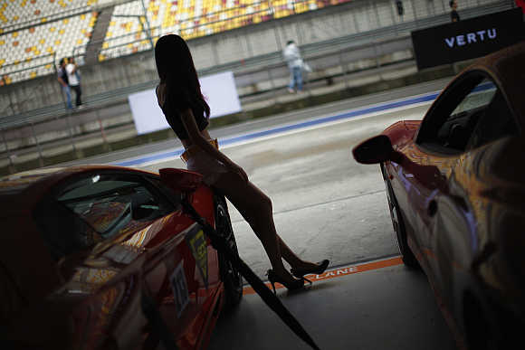 A model leans on a Lamborghini during the sport cars 2012 Super Show in Shanghai.