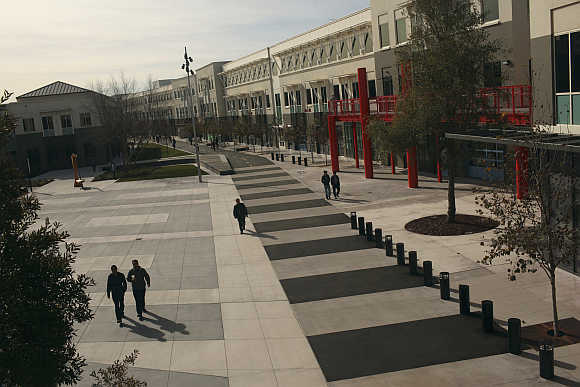 Employees walk along a walking and bicycle path at Facebook headquarters in Menlo Park, California.