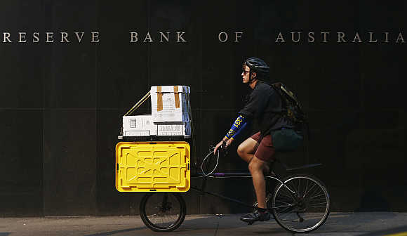 A worker on his bike rides past the Reserve Bank of Australia building in central Sydney.