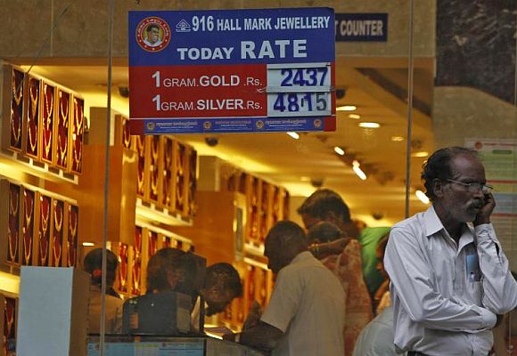 A man speaks over his mobile phone as customers buy gold at a jewellery showroom in the southern Indian city of Chennai.