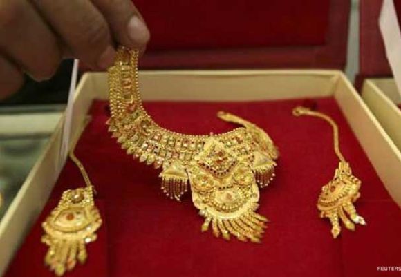 A shopkeeper displays gold jewellery at a shop in Jammu.