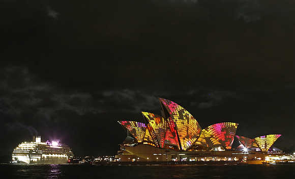 A cruise ship navigates past the Sydney Opera House as 'Play' by The Spinifex Group is projected on its sails as part of Vivid Festival in Sydney, Australia.
