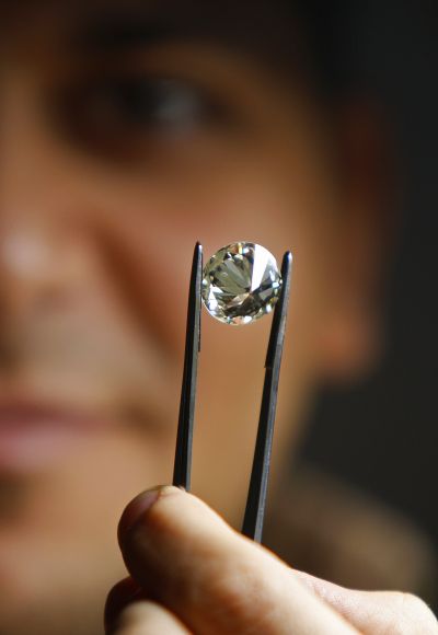 A worker assesses the quality of a diamond before certification.