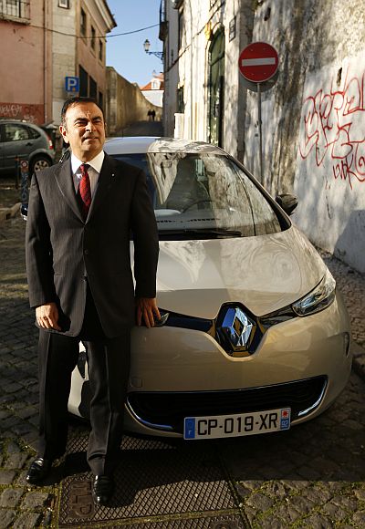 Carlos Ghosn, chairman and chief executive cfficer of Renault, poses next to a Renault Zoe.