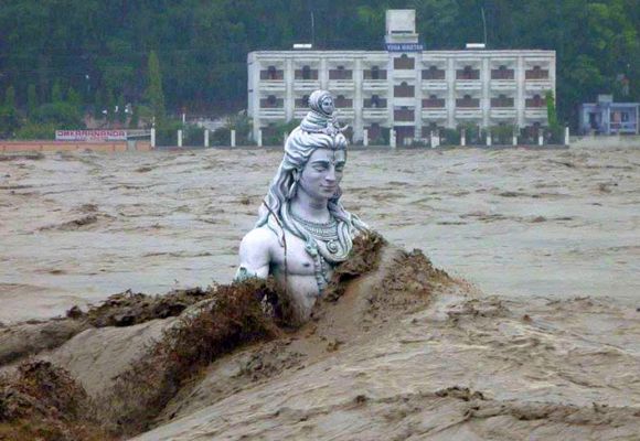 A submerged statue of the Hindu Lord Shiva stands amid the flooded waters of river Ganges at Rishikesh.