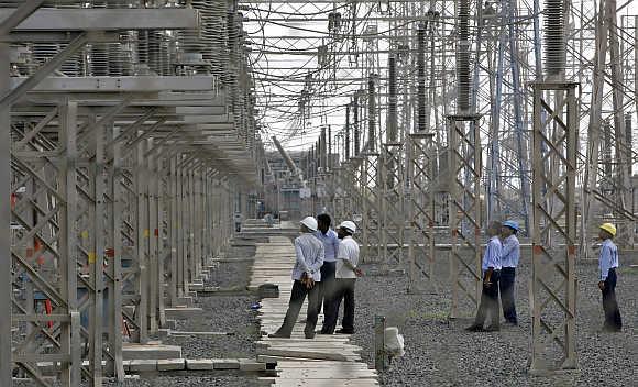 Engineers inspect electric transmission lines at Adani Power Company thermal power plant at Mundra in Gujarat.