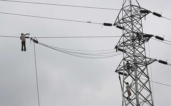 Labourers work at an electric pylon in New Delhi.