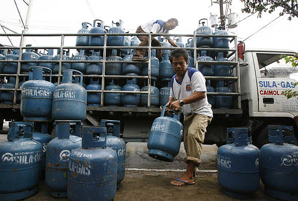 Workers deliver liquid petroleum gas cylinders in Manila, the Philippines.