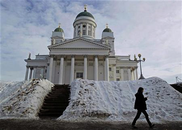 A woman walks past Helsinki cathedral.