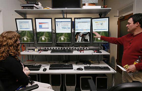 Investigators with the US Federal Trade Commission look at computer monitors in the FTC Internet lab where cyber crime investigations take place in Washington, DC.