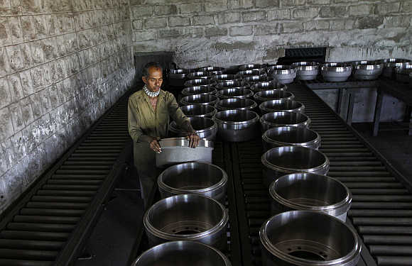 A worker arranges brake drums used in truck wheels at a steel factory in the outskirts of Coimbatore.