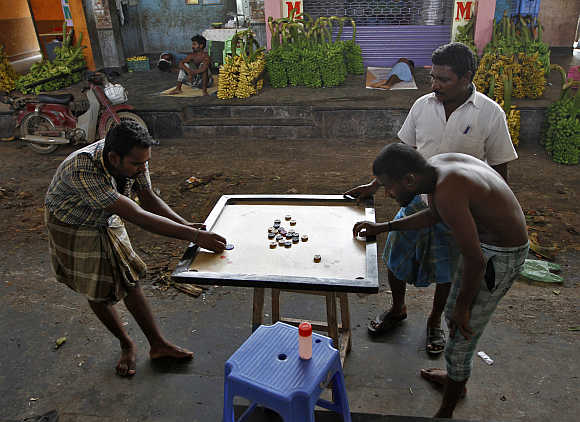 Workers play carom at a wholesale fruit market in Coimbatore.
