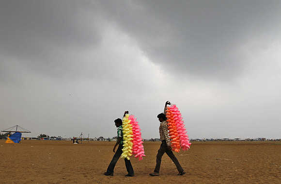 Vendors carry sugar candies for sale at Marina beach in Chennai.