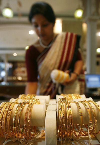 A woman looks at gold jewellery on display at a jewellery showroom.