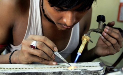 A goldsmith makes ornaments at a workshop in Ahmedabad.