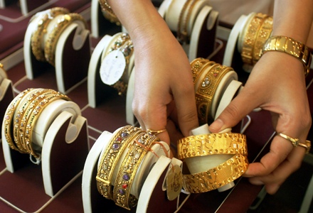 A shopkeeper arranges gold ornaments at a shop in Jammu.