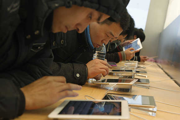 Customers test out iPads in an Apple Store in downtown Shanghai, China.
