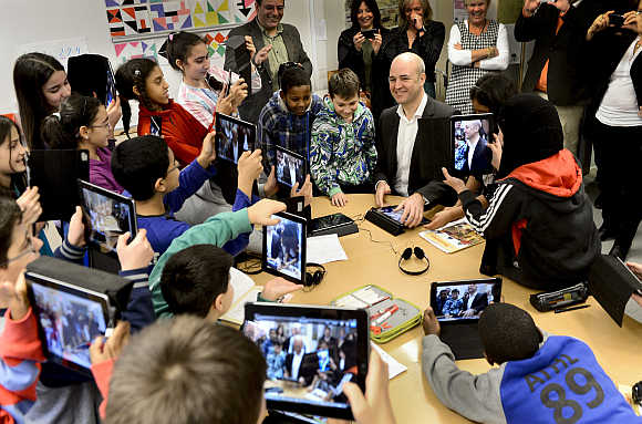 Fifth graders use their iPads to take photos of Sweden's Prime Minister Fredrik Reinfeldt during his visit to Husby School, west of Stockholm.