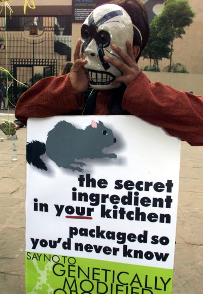 A masked Greenpeace activist shows a sign during a demonstration in New Delhi.