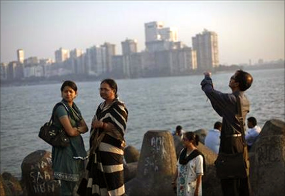 People walk at a seafront promenade in the evening at the Nariman Point financial area in south Mumbai.