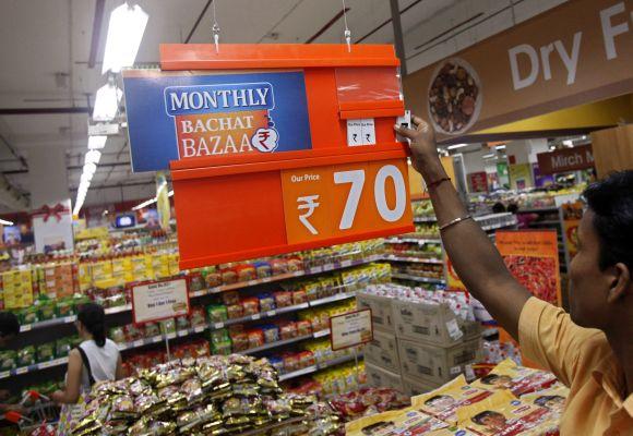 An employee changes the price tag of a product at a retail store.