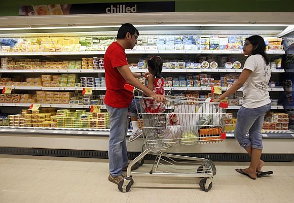 People shop in the chilled foods section of a supermarket.