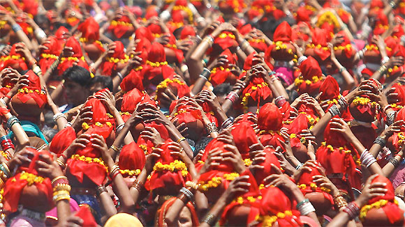 Women carry Kalash, earthen pots containing sacred water with a coconut on top, during a religious procession locally known as Ganga Kalash Yatra in Ahmedabad.
