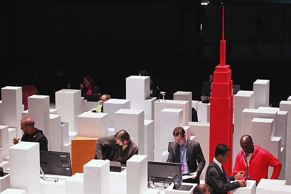 Members of the media examine Microsoft Surface tablet PCs in a scale model of New York in New York.