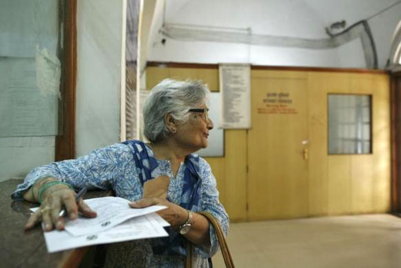 Bulbul Tiwari, 73, writes a telegram to her grandchildren inside the Central Telegraph Office in New Delhi July 10, 2013.