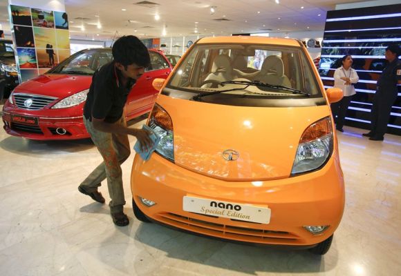 A showroom attendant cleans a Tata Nano car at their flagship showroom in Mumbai.