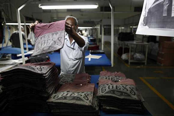 An employee sorts newly finished T-shirts at the Estee garment factory in Tirupur, Tamil Nadu.