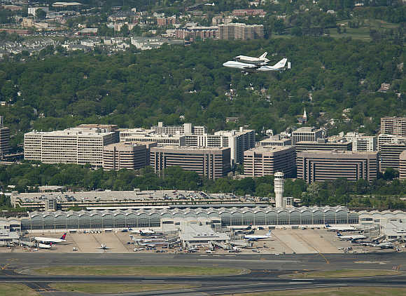 Space Shuttle Discovery, mounted atop a Nasa 747 Shuttle Carrier Aircraft , makes its way past Ronald Reagan Washington National Airport in Washington, DC.