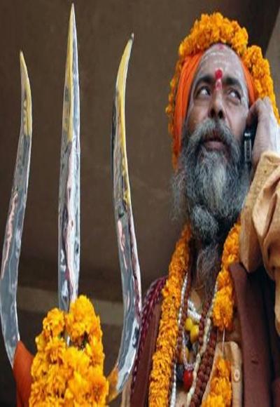 A holy man, is seen talking on a mobile phone in Varanasi.